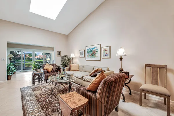 a living room with furniture a lamp a rug and a large window