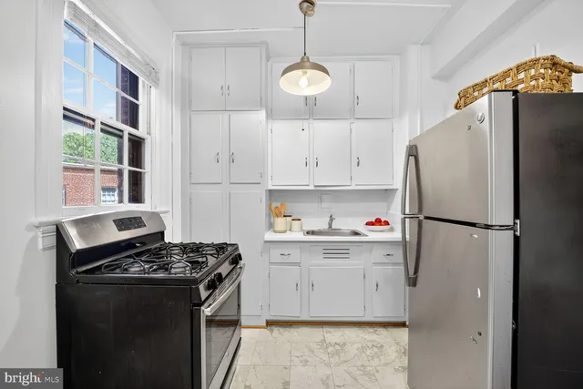 a kitchen with stainless steel appliances granite countertop white cabinets and a stove