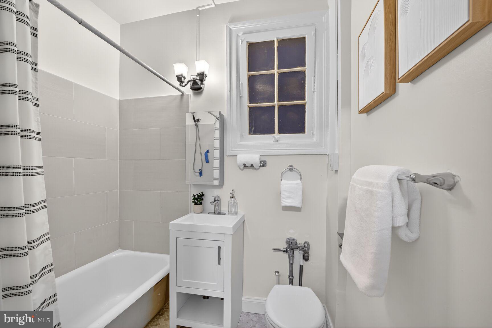 2707 Adams Mill Road Northwest, Unit 303 Washington, DC 20009 - Photo 22 of 27 a bathroom with a toilet sink and shower