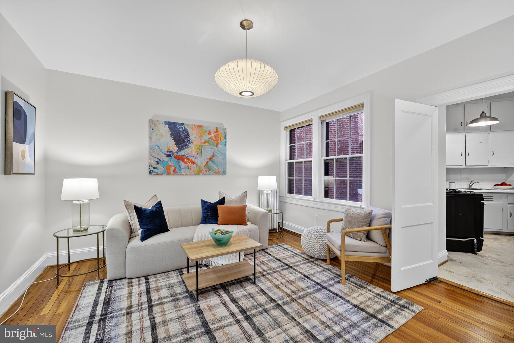 2707 Adams Mill Road Northwest, Unit 303 Washington, DC 20009 - Photo 9 of 27 a living room with furniture and a chandelier