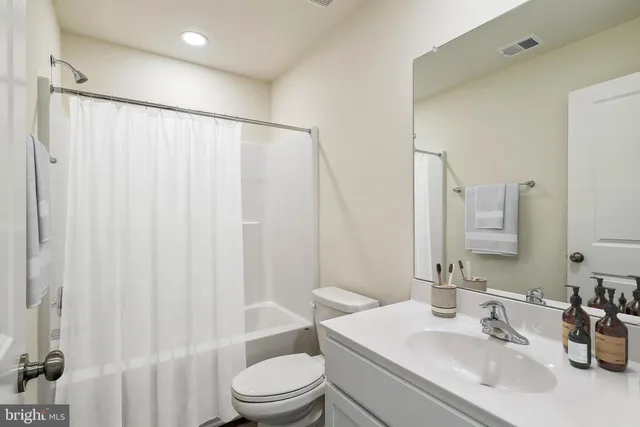 a bathroom with a sink a toilet and shower curtain