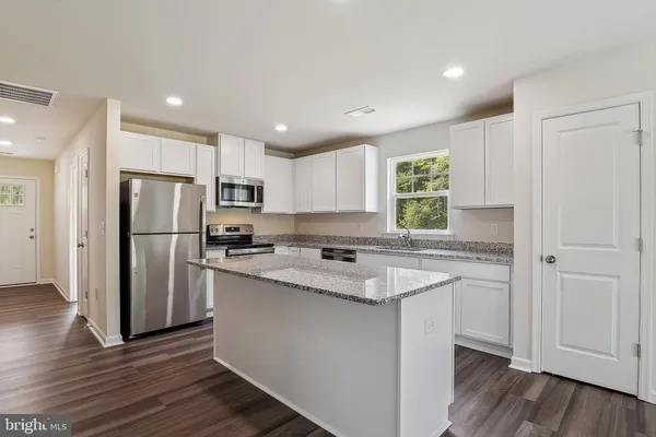 a kitchen with a refrigerator a sink and cabinets