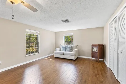 a kitchen with stainless steel appliances granite countertop a refrigerator a sink a stove and white cabinets with wooden floor