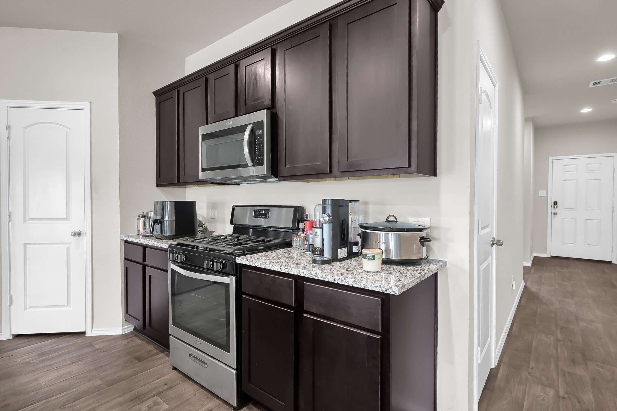 15015 Monserrat Lane Conroe, TX 77304 - Photo 13 of 41 a kitchen with stainless steel appliances granite countertop a stove a sink and a microwave