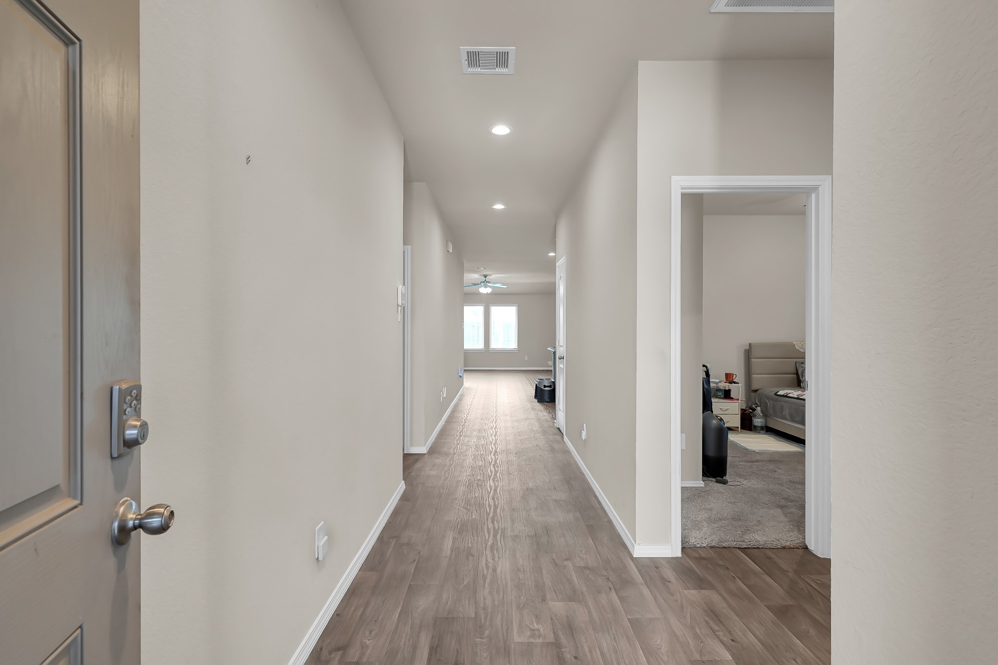 15015 Monserrat Lane Conroe, TX 77304 - Photo 7 of 41 a view of a hallway with wooden floor and a bathroom
