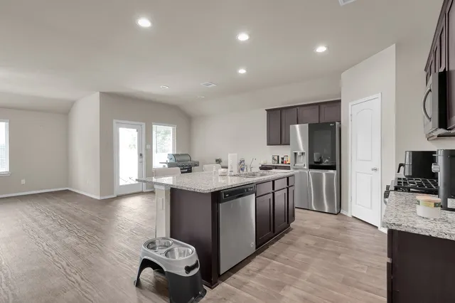 a kitchen with stainless steel appliances granite countertop a sink stove and refrigerator