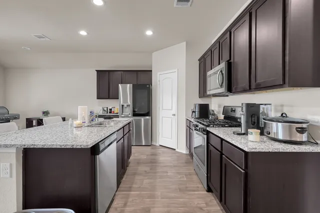 a kitchen with stainless steel appliances granite countertop a sink stove microwave and cabinets