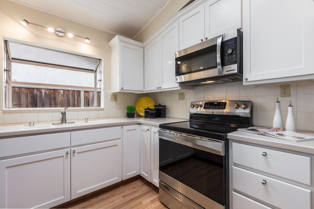1372 Flicker Way Sunnyvale, CA 94087 - Photo 6 of 22 a kitchen with stainless steel appliances granite countertop white cabinets a sink and a stove