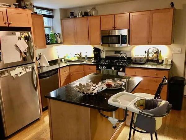 a kitchen with stainless steel appliances wooden floors sink refrigerator and stove