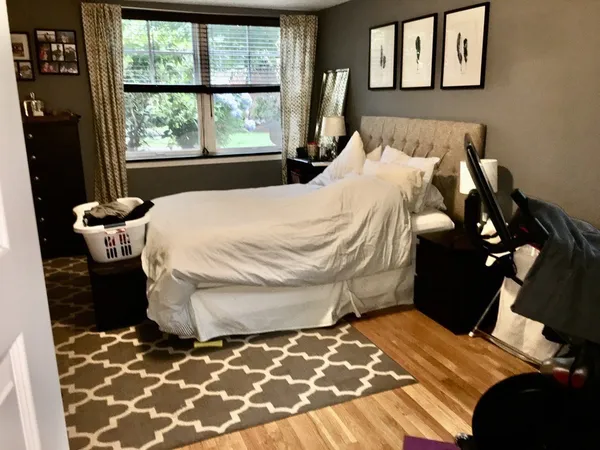 a bedroom with a bed and wooden floor