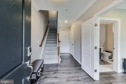 a view of a hallway with wooden floor and staircase