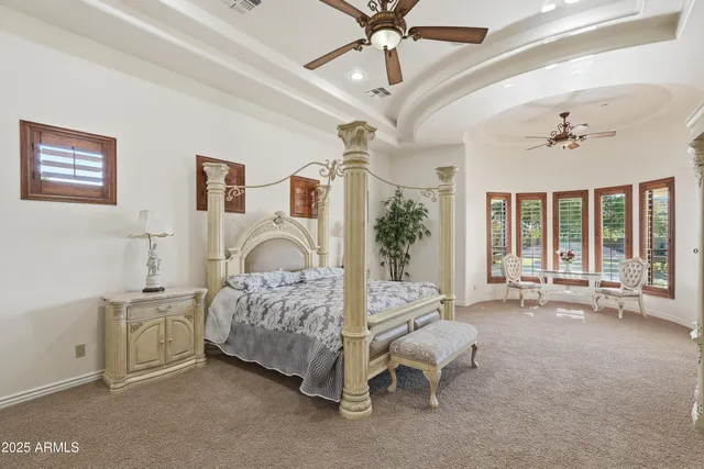 a spacious bedroom with a bed and flat screen tv