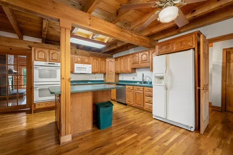 a front view of a house with a yard and trees