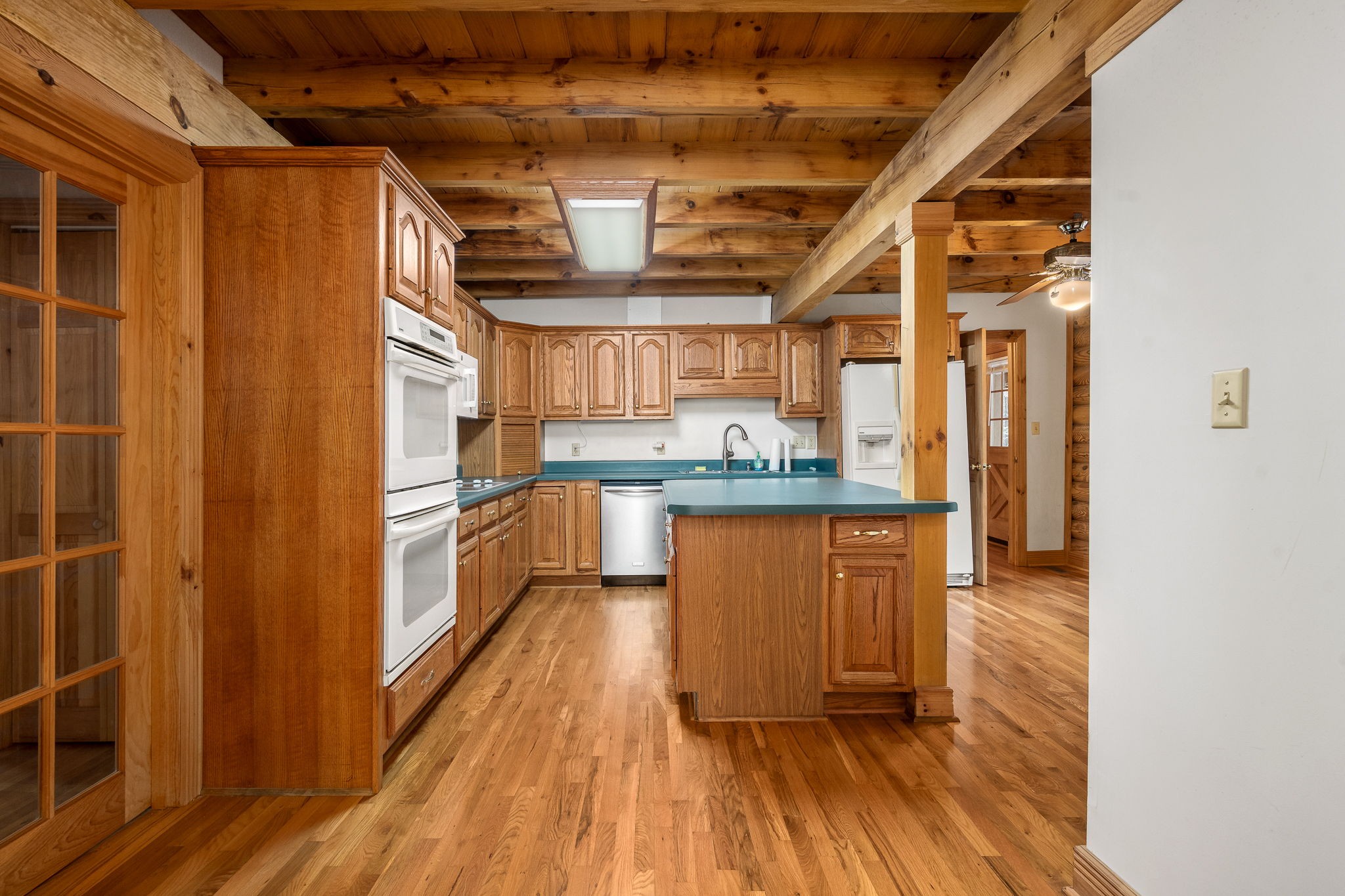 9203 Cobb Road Christiana, TN 37037 - Photo 51 of 96 a kitchen with granite countertop wooden floors and white stainless steel appliances