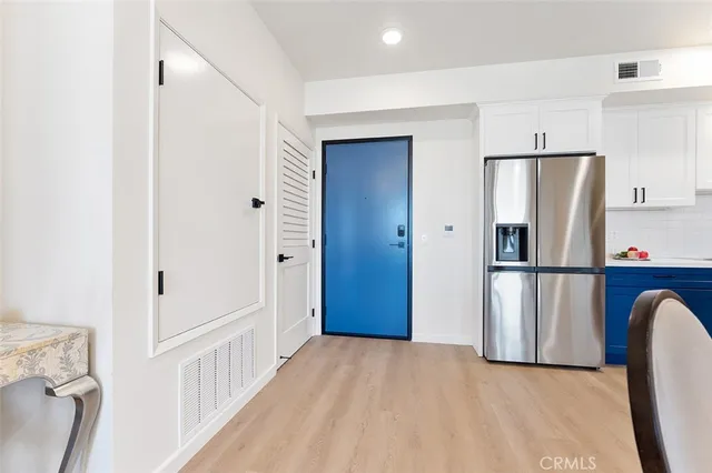 a view of kitchen with refrigerator and wooden floor