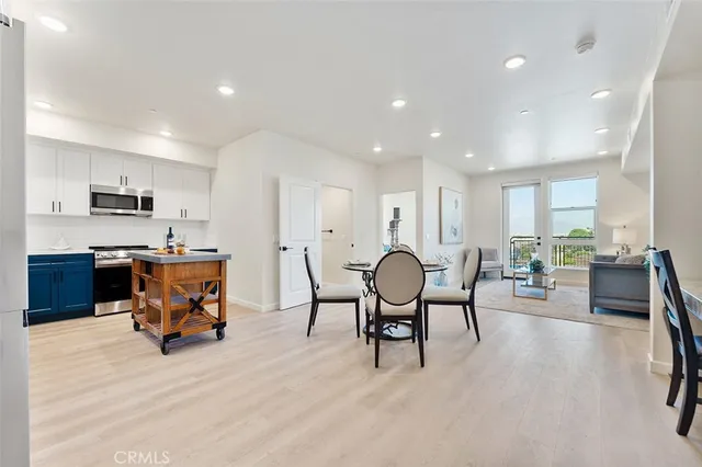 a living room with furniture and a dining table with kitchen view