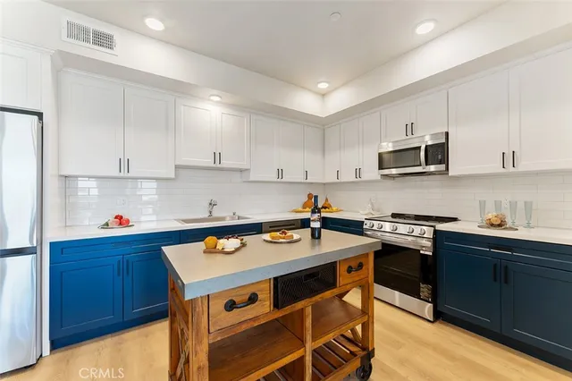 a kitchen with stainless steel appliances a stove a sink a stove and cabinets