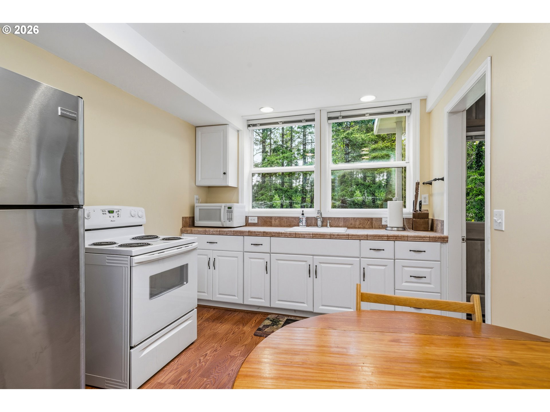 36725 North Highway 101 Nehalem, OR 97131 - Photo 27 of 40 a kitchen with stainless steel appliances granite countertop a stove a sink dishwasher a refrigerator white cabinets and wooden floor
