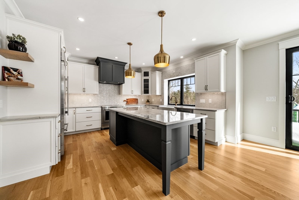 15 Whisper Way Hopkinton, MA 01748 - Photo 7 of 41 a kitchen with stainless steel appliances kitchen island granite countertop a sink a stove and a wooden floors