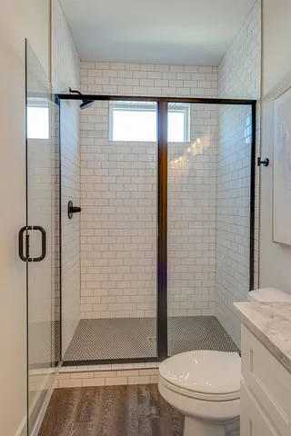 a bathroom with a shower a toilet and sink