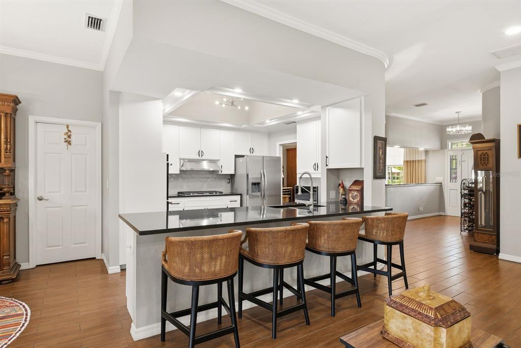2351 Northeast Coachman Road Clearwater, FL 33765 - Photo 16 of 47 a dining hall with stainless steel appliances kitchen island granite countertop a dining table chairs and sink