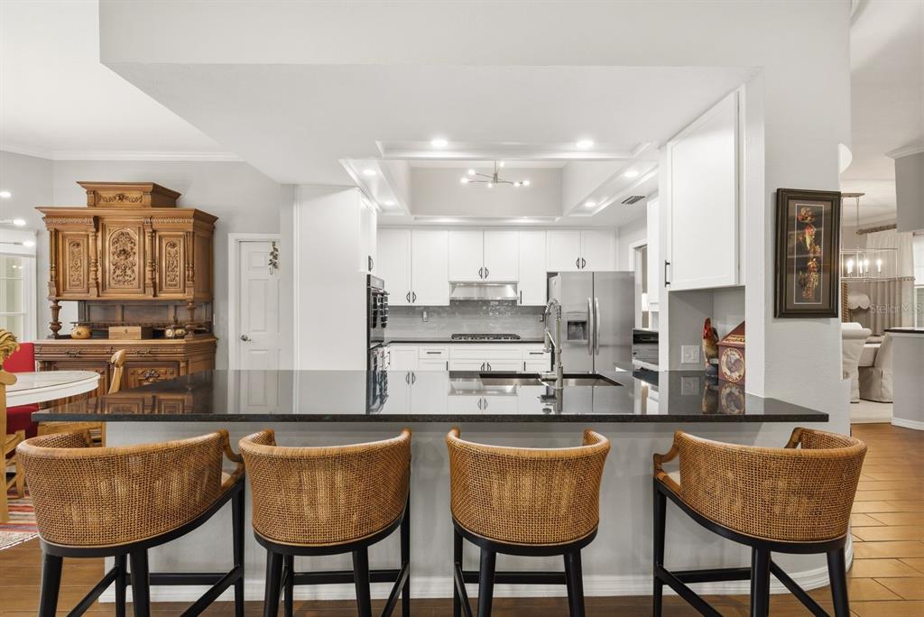 2351 Northeast Coachman Road Clearwater, FL 33765 - Photo 17 of 47 a kitchen with stainless steel appliances granite countertop a dining table chairs and view living room