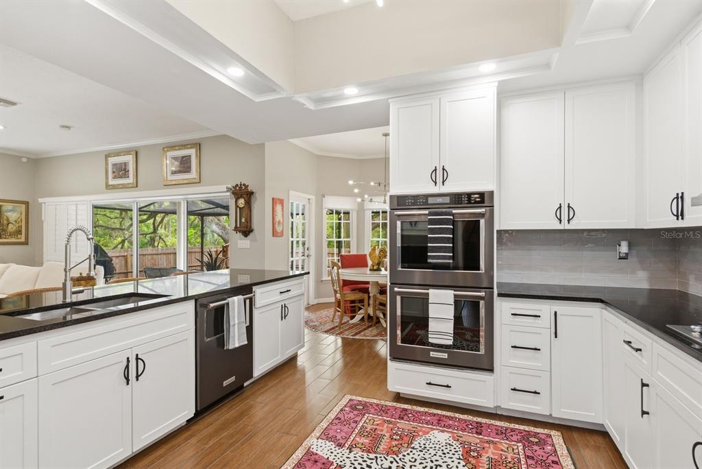 2351 Northeast Coachman Road Clearwater, FL 33765 - Photo 20 of 47 a kitchen with stainless steel appliances a stove a sink and white cabinets