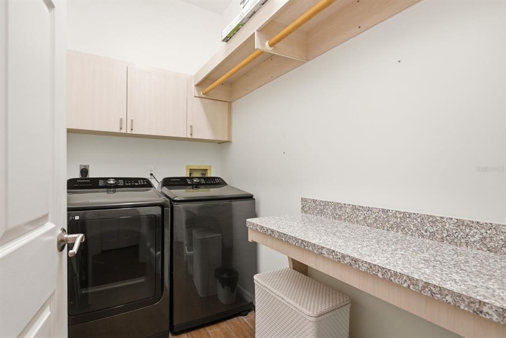 2351 Northeast Coachman Road Clearwater, FL 33765 - Photo 35 of 47 a utility room with granite countertop cabinets washer and dryer