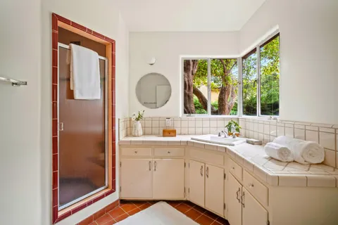 a en suite bathroom with a granite countertop sink and a mirror