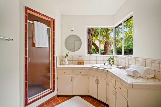 a en suite bathroom with a granite countertop sink and a mirror