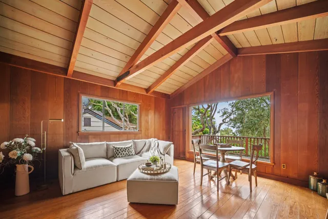 a living room with furniture a table and a large window