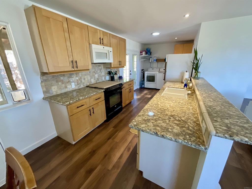 38281 Western Hills Road Anza, CA 92539 - Photo 9 of 75 a large kitchen with kitchen island granite countertop wooden cabinets a stove and a sink