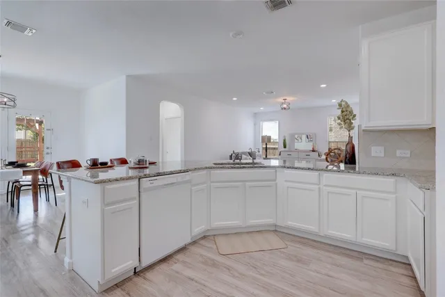 a kitchen with white cabinets and sink