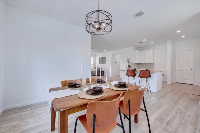 a dining room with furniture a table and kitchen view