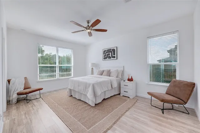 a spacious bedroom with a bed a couch and a window