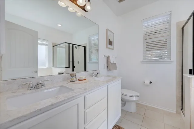 a bathroom with a granite countertop sink mirror vanity and toilet