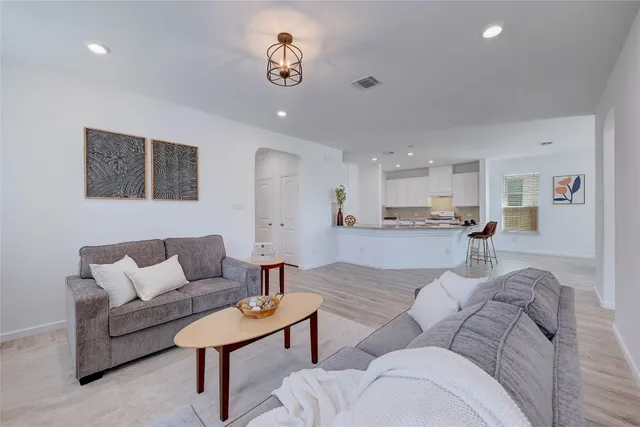 a living room with furniture and kitchen view