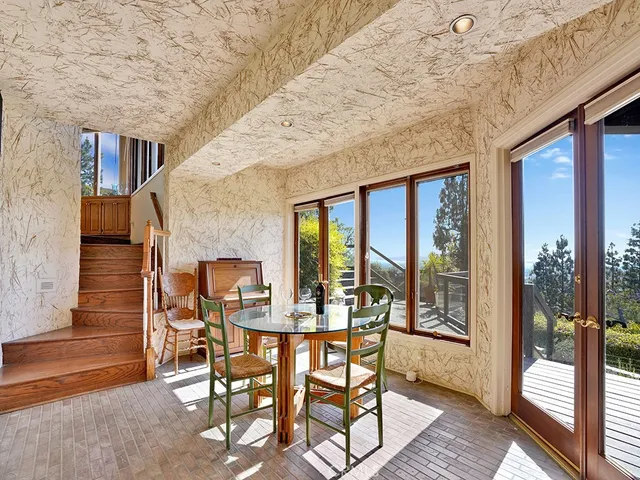 a view of a dining room with furniture large windows and wooden floor