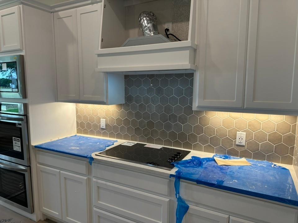 410 Cobb Road Leonard, TX 75452 - Photo 9 of 24 Kitchen featuring white shaker-style cabinetry, a hexagon tile backsplash, under-cabinet lighting, a built-in double oven, and an integrated cooktop
