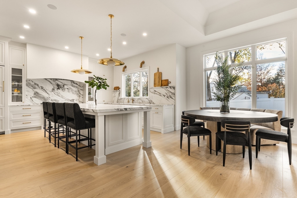 335 Heath Street Brookline, MA 02467 - Photo 5 of 38 a kitchen with stainless steel appliances kitchen island granite countertop a table chairs and a wooden floor