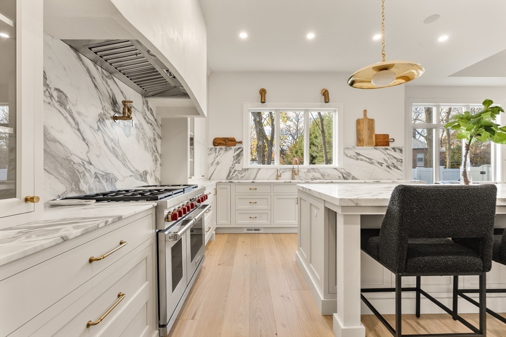 335 Heath Street Brookline, MA 02467 - Photo 8 of 38 a kitchen with stainless steel appliances granite countertop a stove and a sink