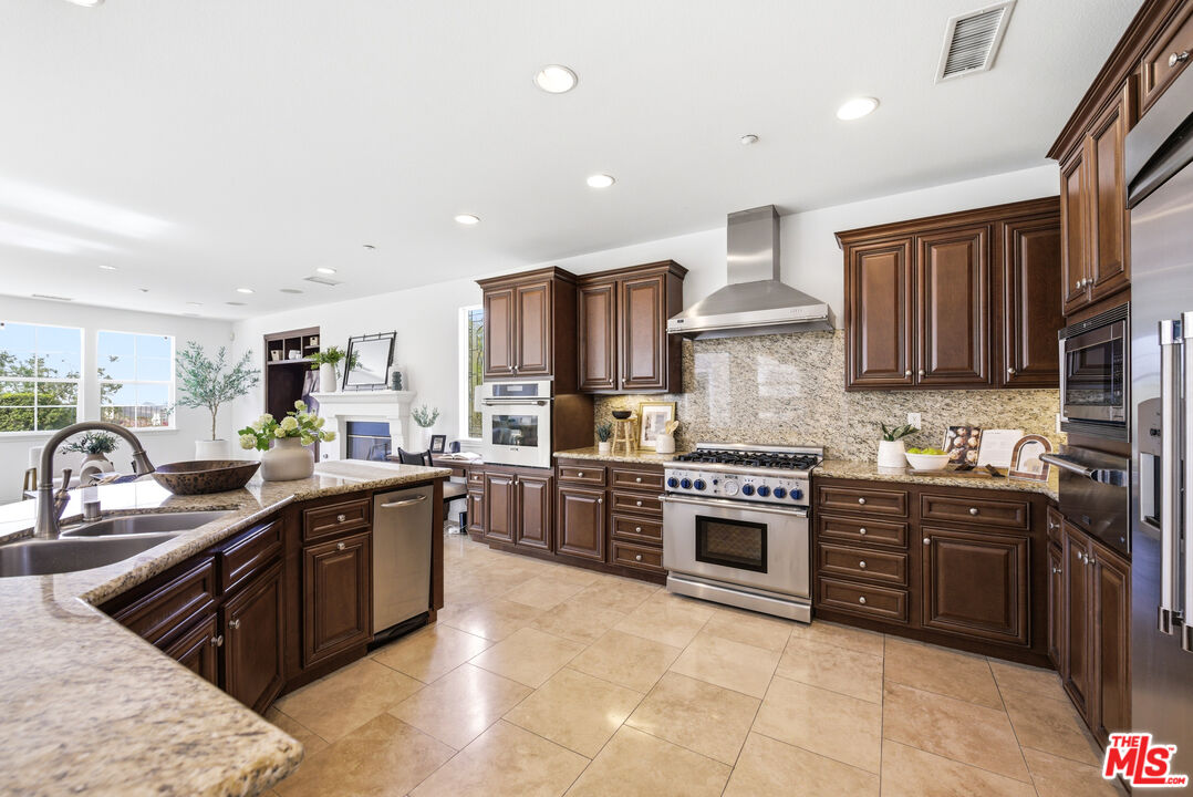 3447 Sentinel Court Simi Valley, CA 93065 - Photo 4 of 19 a kitchen with stainless steel appliances granite countertop a stove top oven a sink dishwasher and a refrigerator