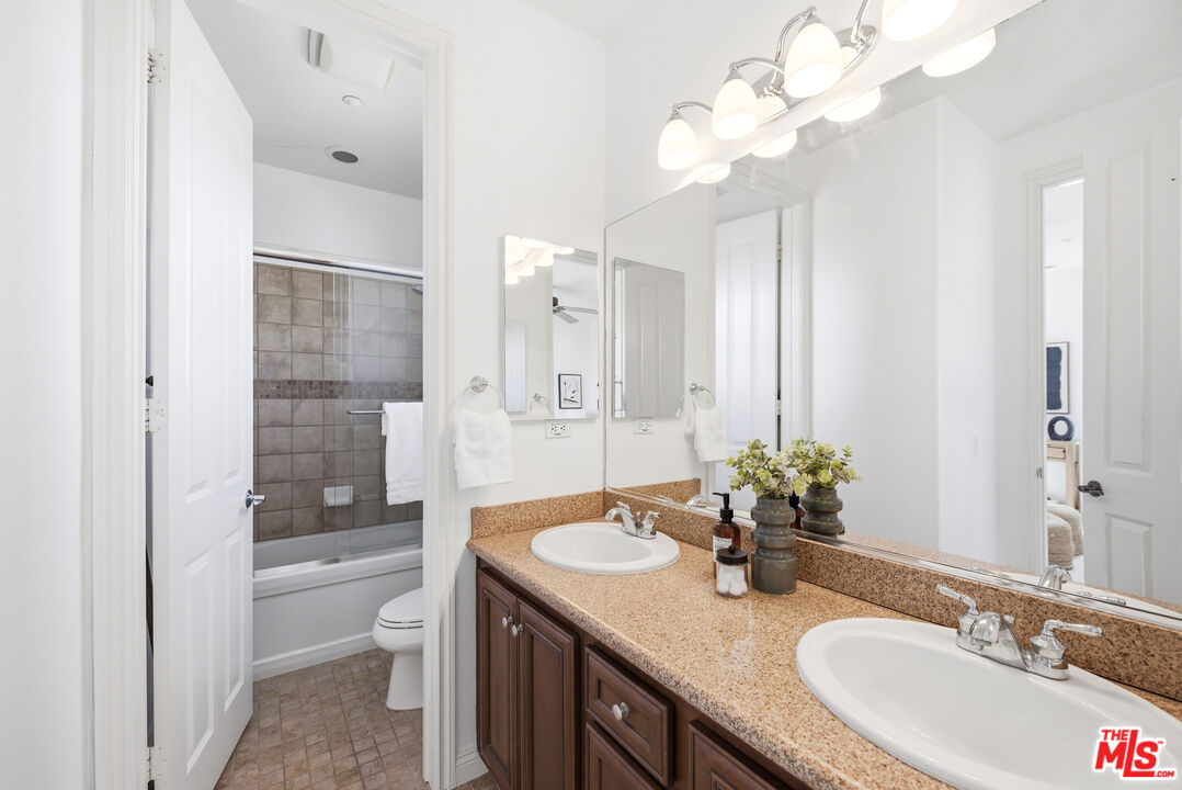 3447 Sentinel Court Simi Valley, CA 93065 - Photo 10 of 19 a bathroom with a granite countertop sink a toilet and a mirror