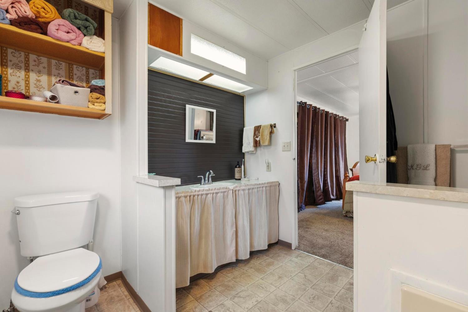 10383 Larkin Road, Unit 15 Live Oak, CA 95953 - Photo 20 of 32 a bathroom with a toilet a sink and glass door