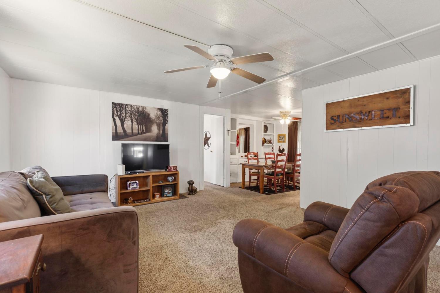 10383 Larkin Road, Unit 15 Live Oak, CA 95953 - Photo 9 of 32 a living room with furniture and a flat screen tv with wooden floor