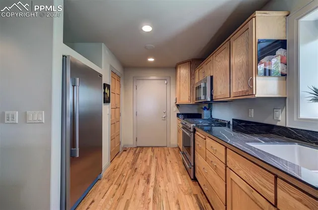 a kitchen with stainless steel appliances granite countertop a refrigerator and a stove top oven