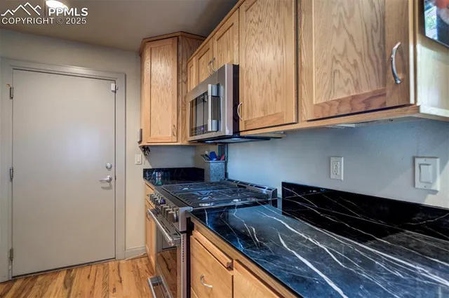 a kitchen with stainless steel appliances granite countertop a stove and a microwave