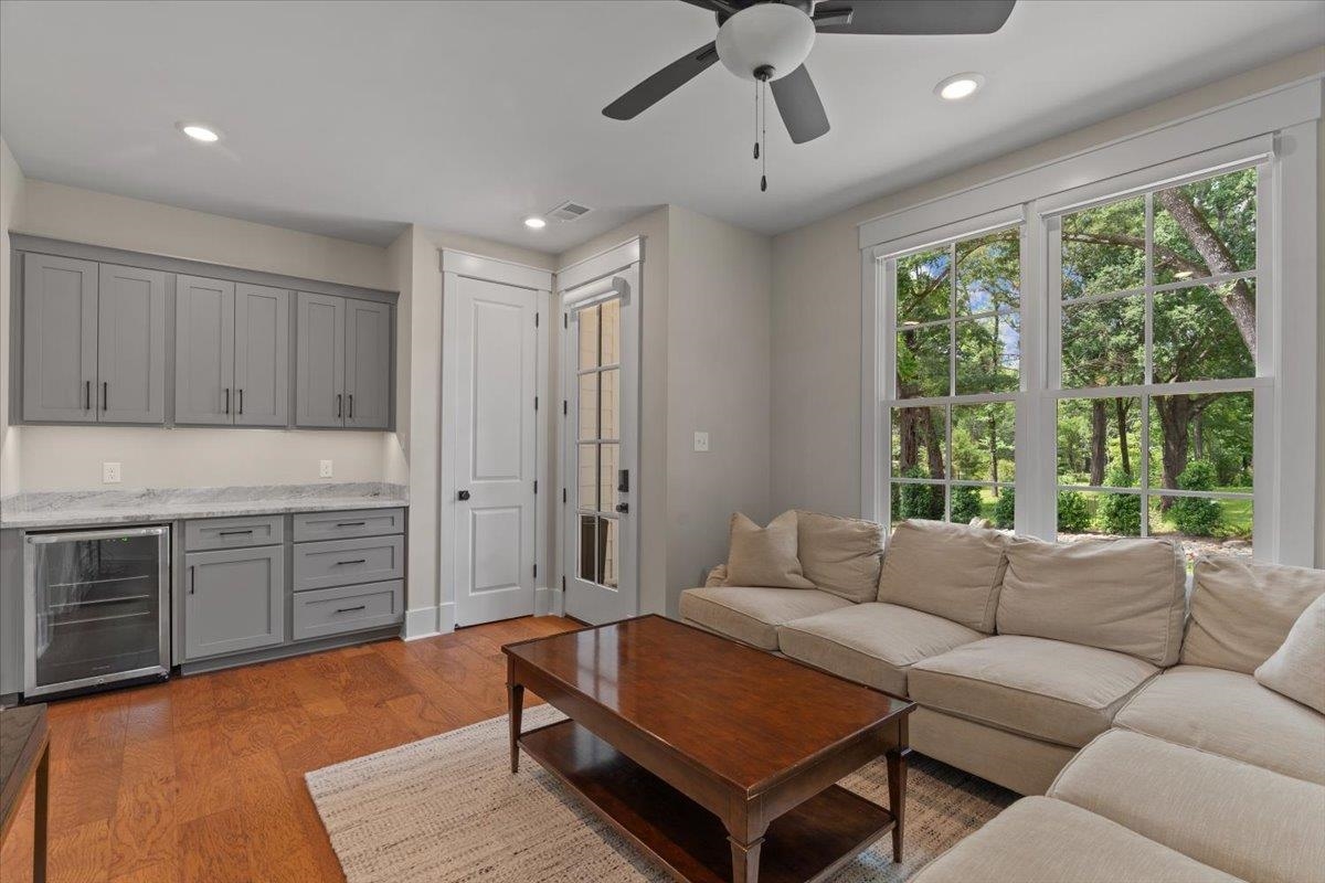 240 Burrows Road Collierville, TN 38017 - Photo 21 of 37 Hardwood flooring throughout featuring a built-in wet bar with gray cabinetry, an integrated beverage cooler, and a light-colored countertop