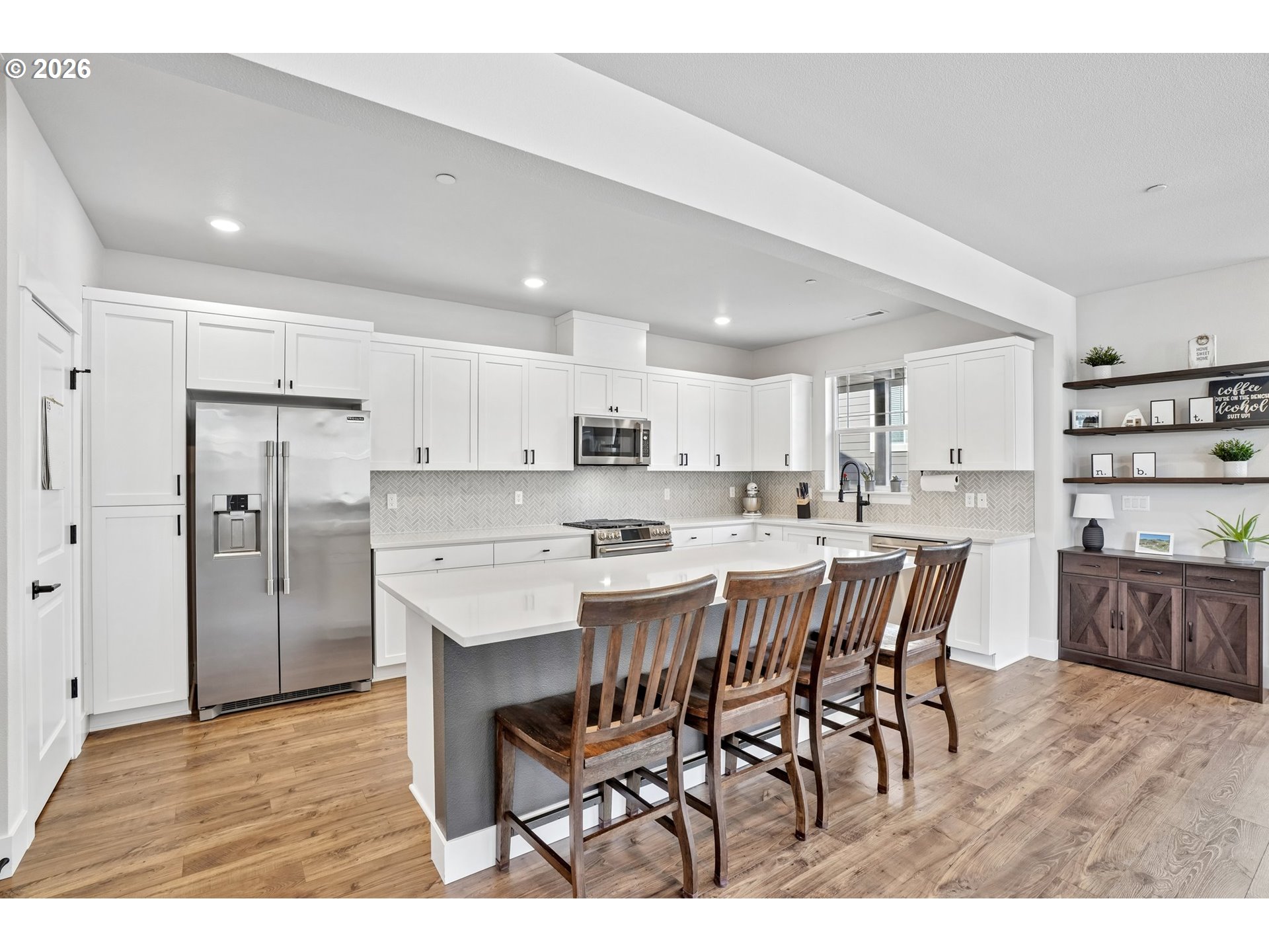 16823 Southwest Colorado Lane Tigard, OR 97224 - Photo 25 of 48 a kitchen with stainless steel appliances kitchen island granite countertop a dining table chairs and white cabinets