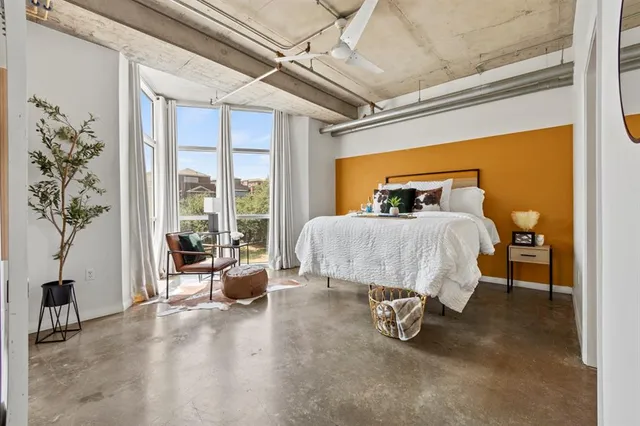 a bedroom with furniture and a large window